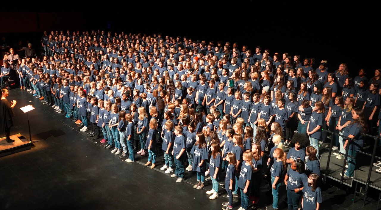 Students in every grade level sing together on stage at the All-District Choir Concert